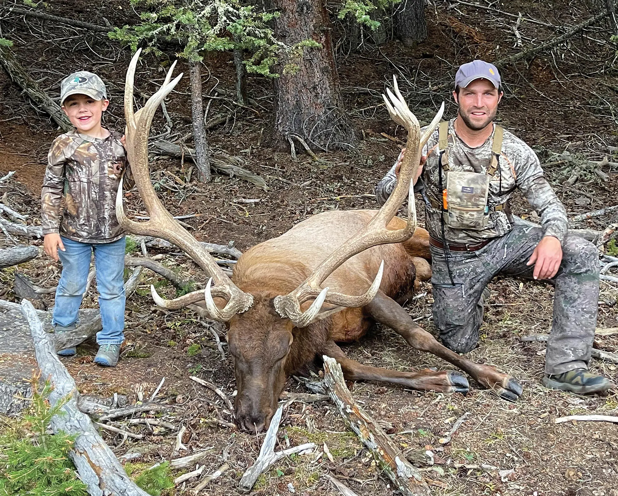 Father and son posing with a downed Wyoming bulk elk