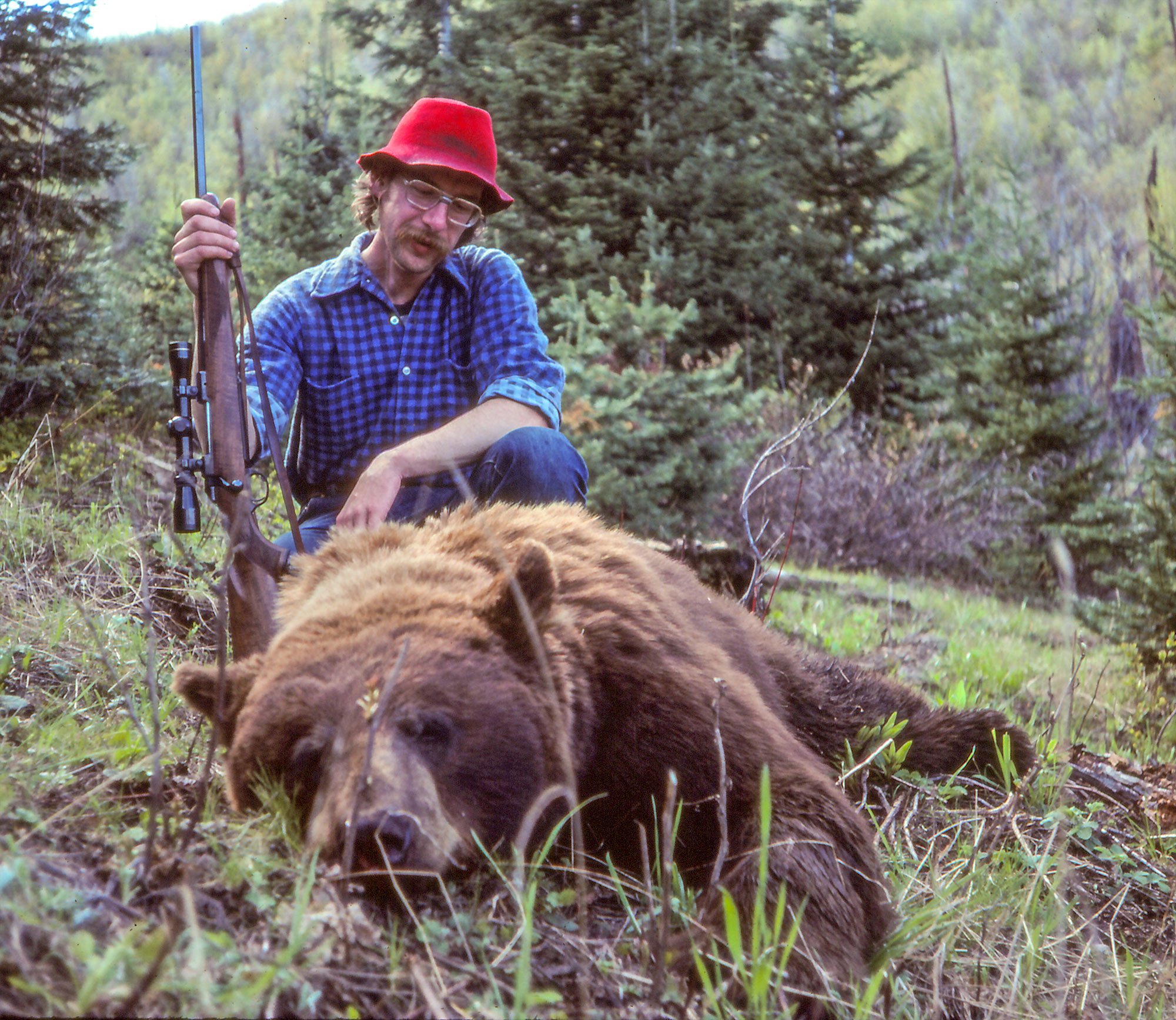 a hunter with a great spring bear harvested with a rifle.
