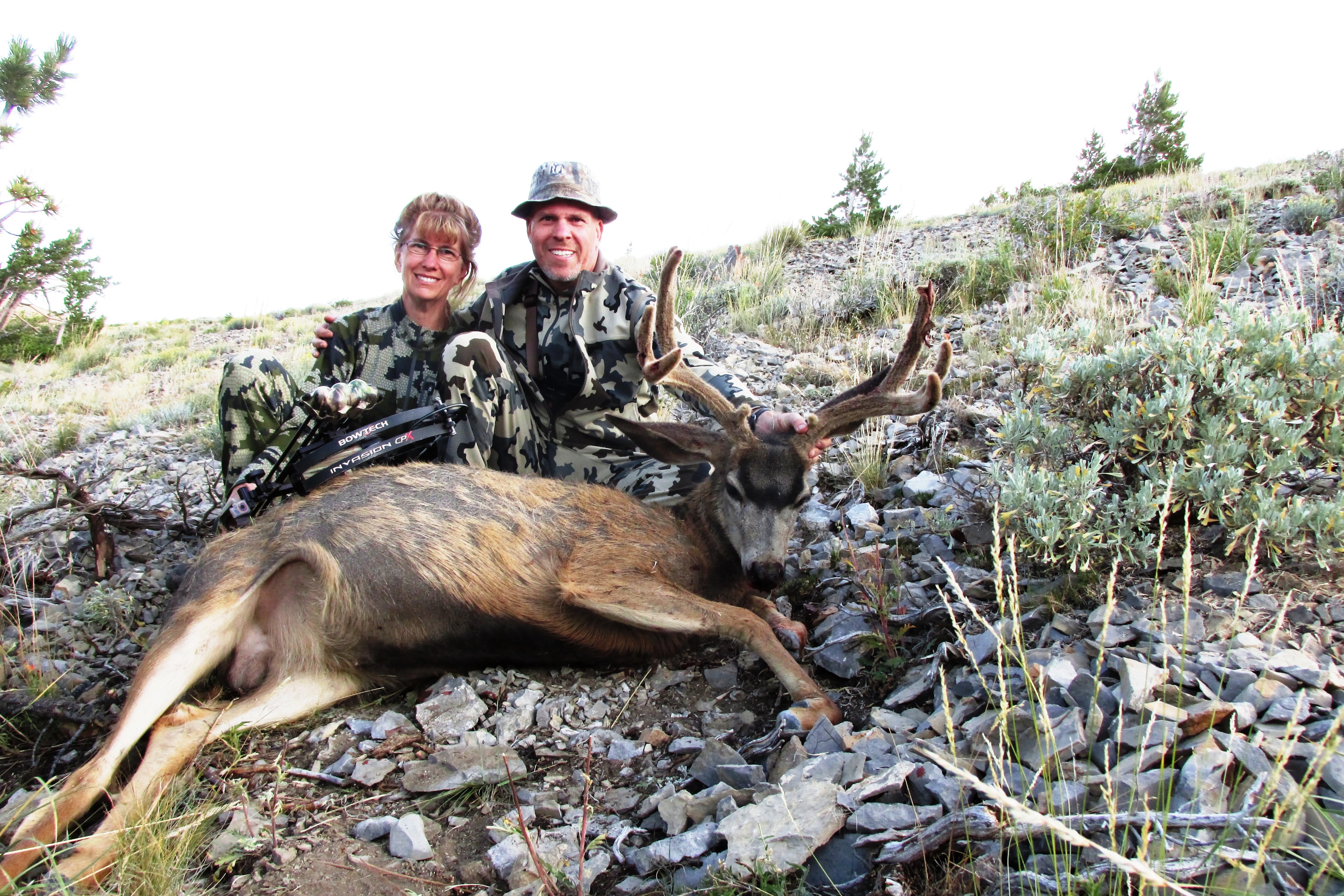 Roy and his wife who are both bowhunters with a mule deer buck.
