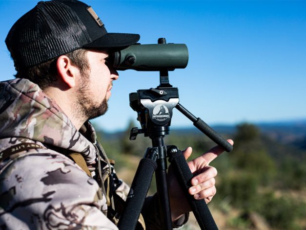 A person using a pair of binoculars with the Outdoorsmans Fluid Head